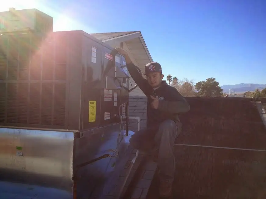 HVAC technician performing HVAC Inspection on a rooftop unit in Robinson